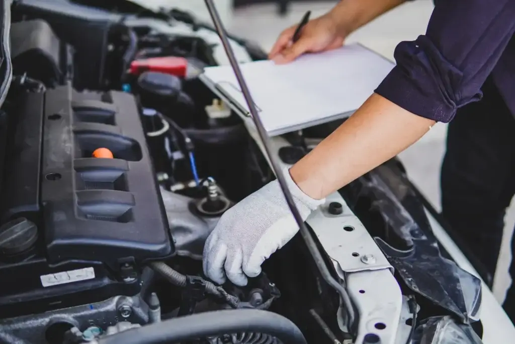 Mechanic inspecting an engine with a checklist
