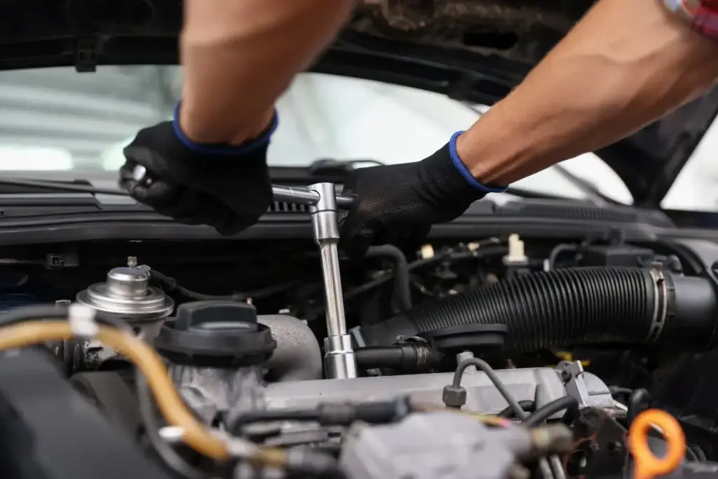 Mechanic using a socket wrench on an engine